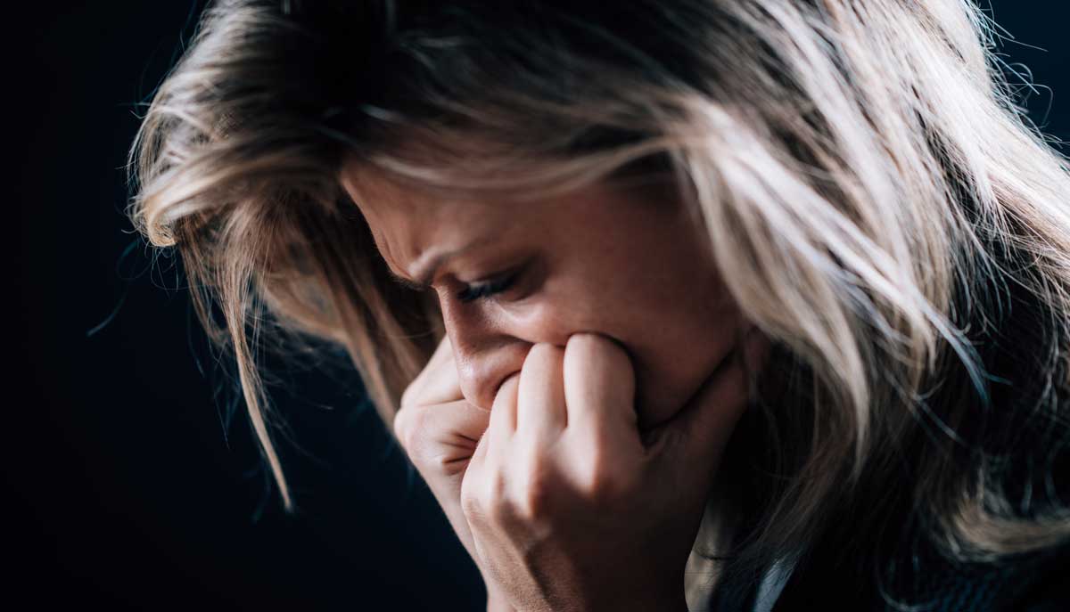 Portret van een angstige, rusteloze vrouw op een donkere achtergrond