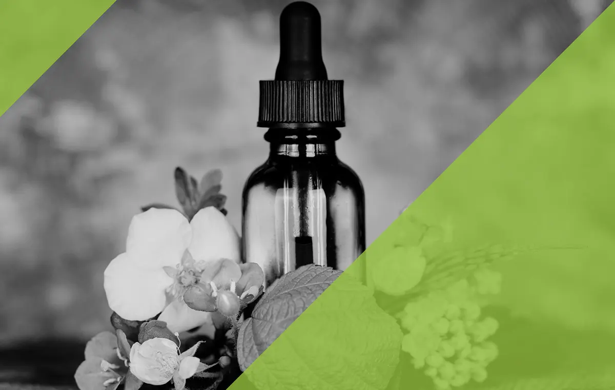 De bloemen van een medicinale plant liggen naast een pipetfles.